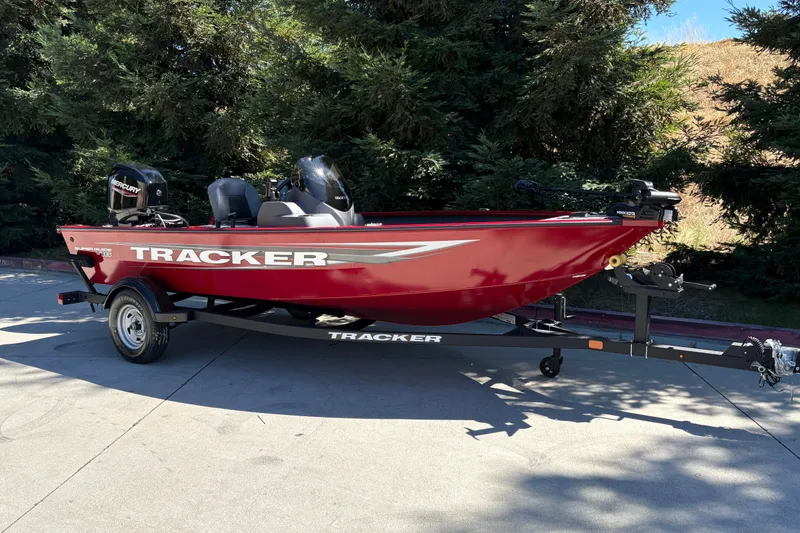 Slide: The Image of Red 2026 Tracker Super Guide V-16 SC boat on trailer, parked outdoors. - 3