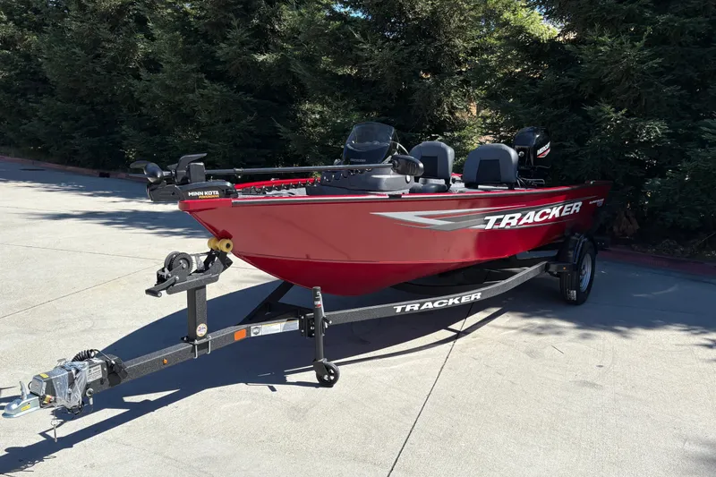 Slide: The Image of 2026 Tracker Super Guide V-16 SC boat on trailer, red exterior, parked outdoors. - 4