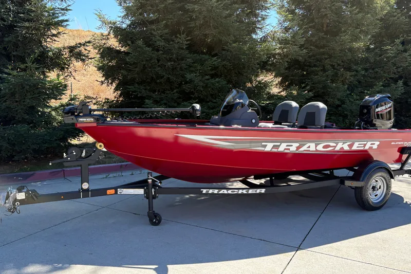 Slide: The Image of Red 2026 Tracker Super Guide V-16 SC boat on trailer, parked outdoors. - 6