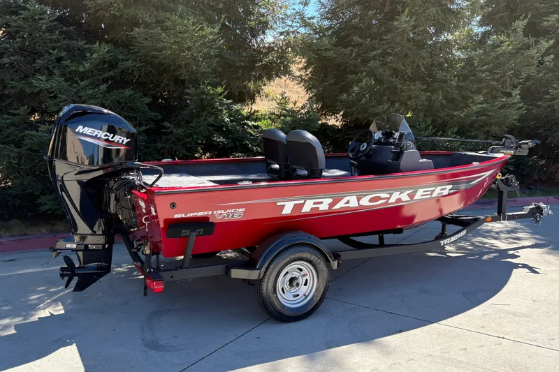 Slide: The Image of 2026 Tracker Super Guide V-16 SC boat with Mercury engine, parked on a trailer. - 2