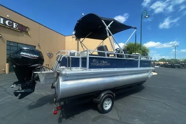 The Image of 2026 Sun Tracker Bass Buggy 18 DLX pontoon boat with Mercury engine on trailer. - 0