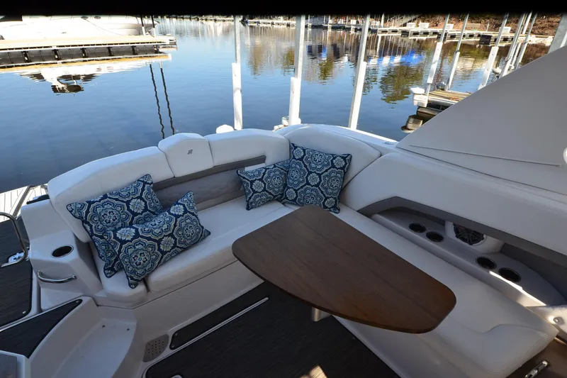 Slide: The Image of 2018 Four Winns H350 boat interior with cushioned seating and decorative pillows. - 18
