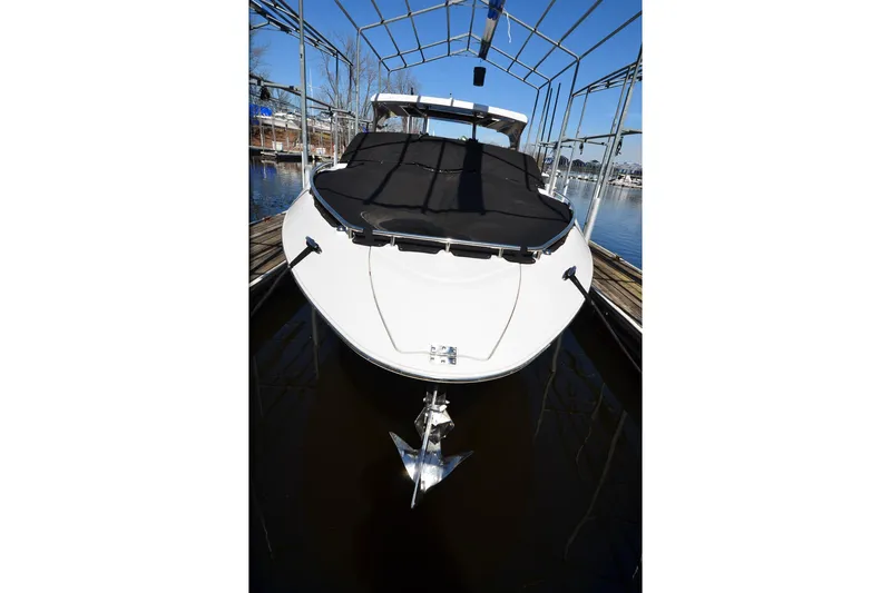 Slide: The Image of 2018 Four Winns H350 boat docked, covered, with a visible anchor. - 23