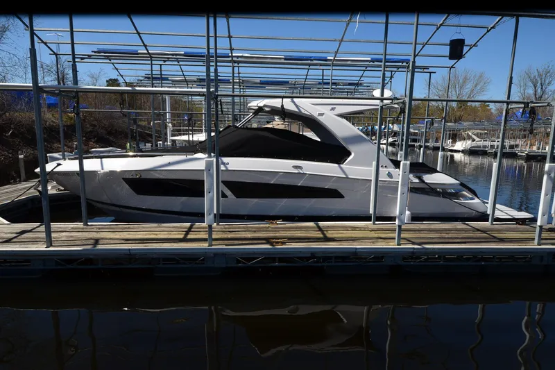 Slide: The Image of 2018 Four Winns H350 boat docked in a marina under a metal canopy. - 25
