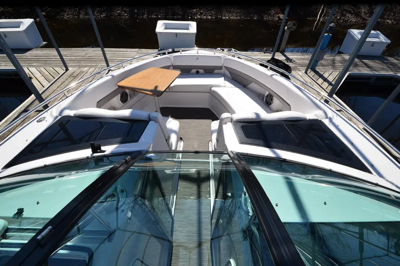 Slide: The Image of 2018 Four Winns H350 boat with spacious seating and wooden table on deck. - 30