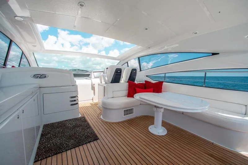 Slide: The Image of Luxurious 2007 Pershing 56 yacht interior with white seating, red cushions, and ocean view. - 10