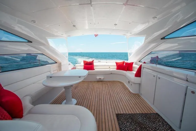 Slide: The Image of Luxurious 2007 Pershing 56 yacht interior with ocean view, featuring white seating and red cushions. - 11