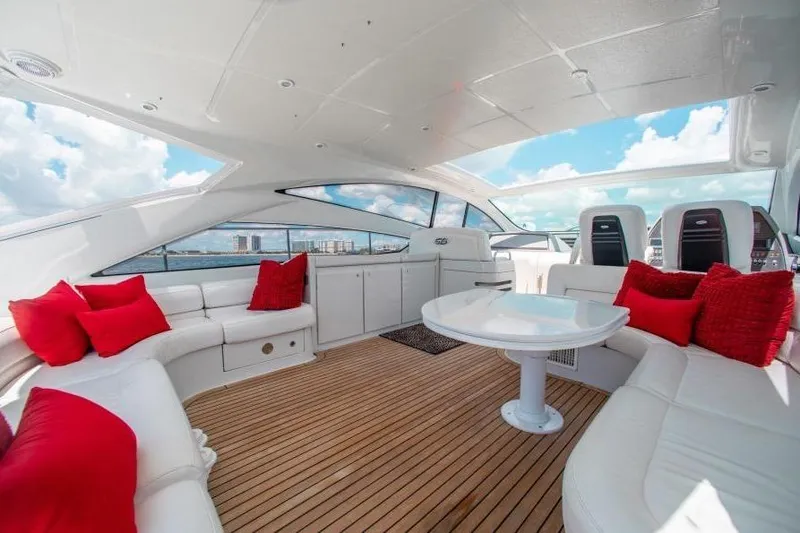 Slide: The Image of Luxurious 2007 Pershing 56 yacht interior with white seating, red cushions, and wooden flooring. - 12