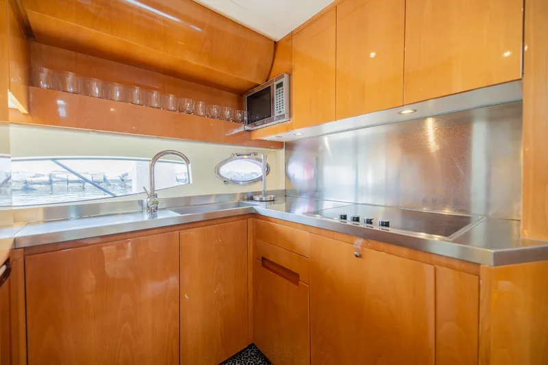 Slide: The Image of Luxurious kitchen interior of 2007 Pershing 56 yacht with wooden cabinetry and stainless steel appliances. - 16
