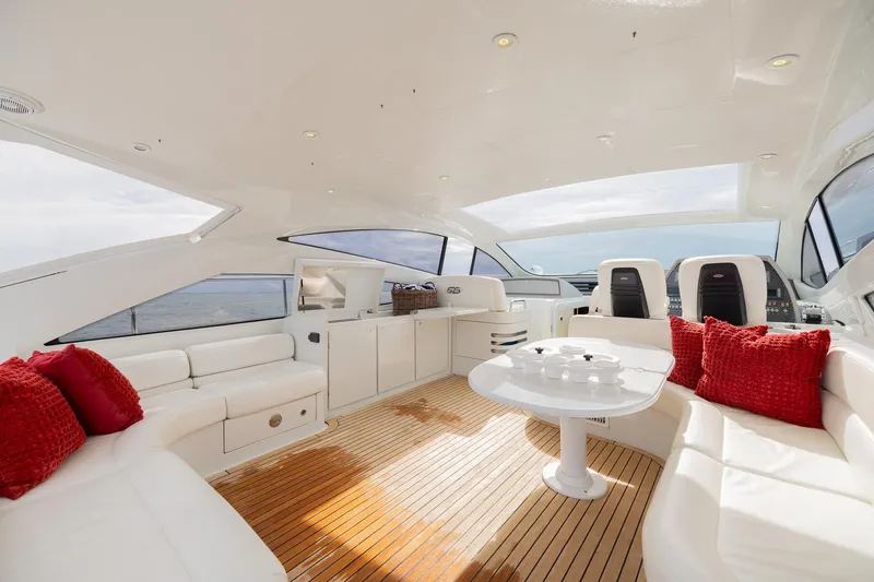 Slide: The Image of Luxurious 2007 Pershing 56 yacht interior with white seating, red cushions, and wooden flooring. - 28