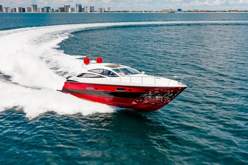 Slide: The Image of Red 2007 Pershing 56 yacht cruising on open water near city skyline. - 3