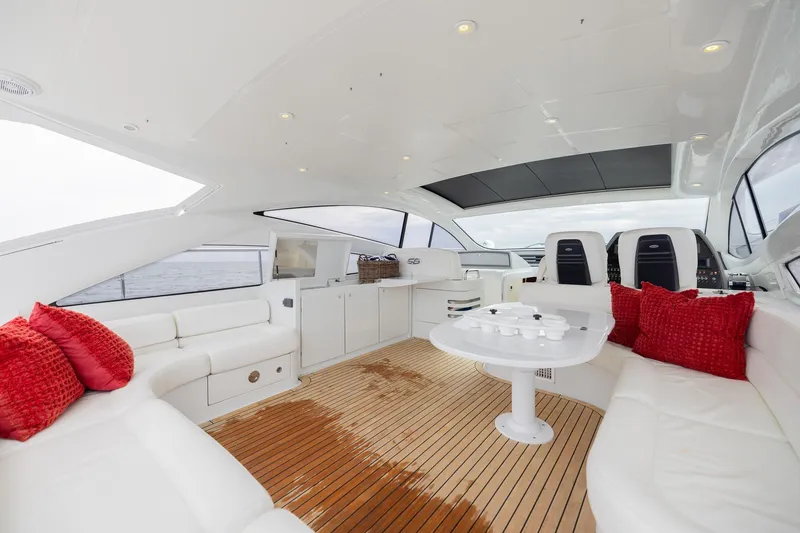 Slide: The Image of Luxurious 2007 Pershing 56 yacht interior with white seating, red cushions, and wooden flooring. - 34