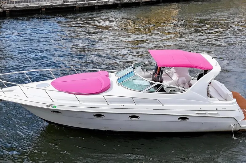 The Image of 2001 Sea Ray 340 Sundancer yacht with pink canopy and cover on the water. - 0