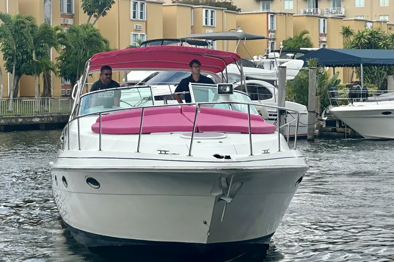 Slide: The Image of 2001 Sea Ray 340 Sundancer boat with pink cushions, docked near waterfront buildings. - 12