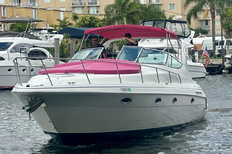 Slide: The Image of 2001 Sea Ray 340 Sundancer with pink canopy cruising in a marina. - 14