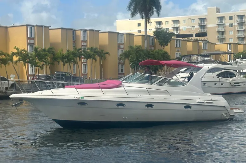 Slide: The Image of 2001 Sea Ray 340 Sundancer yacht with pink canopy docked near yellow buildings. - 15