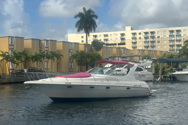 Slide: The Image of 2001 Sea Ray 340 Sundancer yacht docked near waterfront apartments, under cloudy skies. - 17