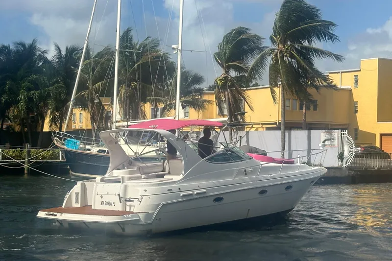 Slide: The Image of 2001 Sea Ray 340 Sundancer yacht docked near palm trees and yellow buildings. - 18