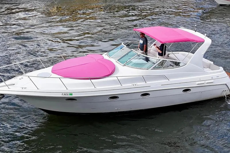 Slide: The Image of 2001 Sea Ray 340 Sundancer boat with pink canopy and sunpad on the water. - 2