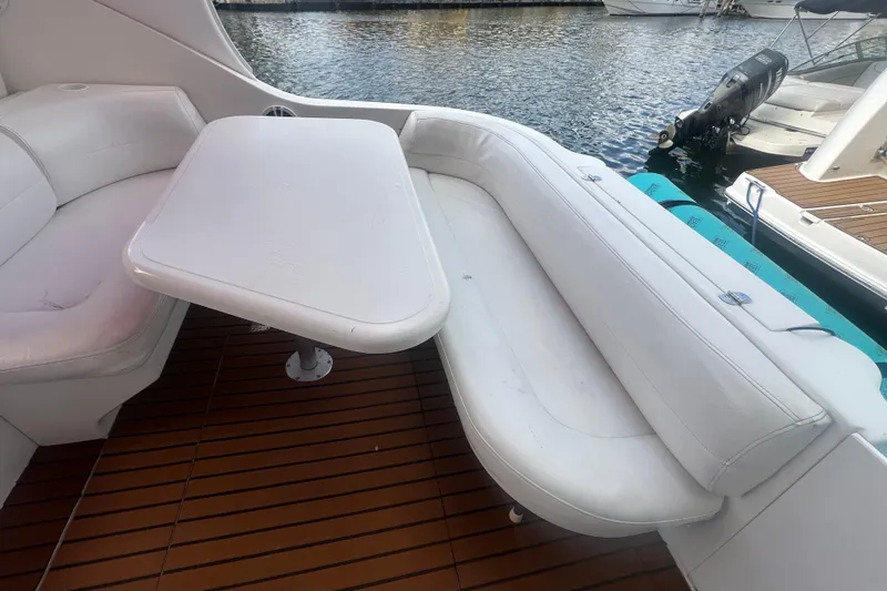 Slide: The Image of Luxury seating area on 2001 Sea Ray 340 Sundancer yacht with white cushions and table. - 26