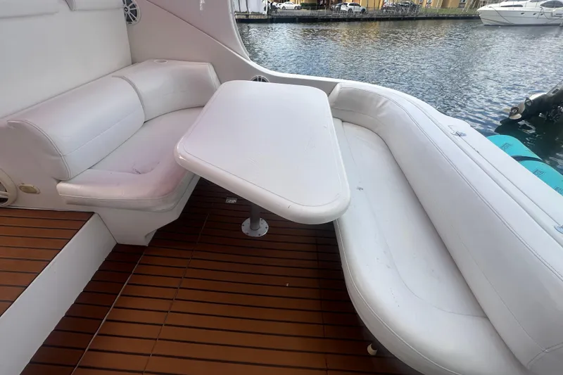 Slide: The Image of Interior seating area of a 2001 Sea Ray 340 Sundancer yacht with white cushions and wooden flooring. - 27