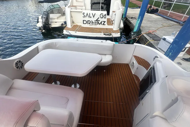 Slide: The Image of 2001 Sea Ray 340 Sundancer boat interior with seating and table, docked at marina. - 28