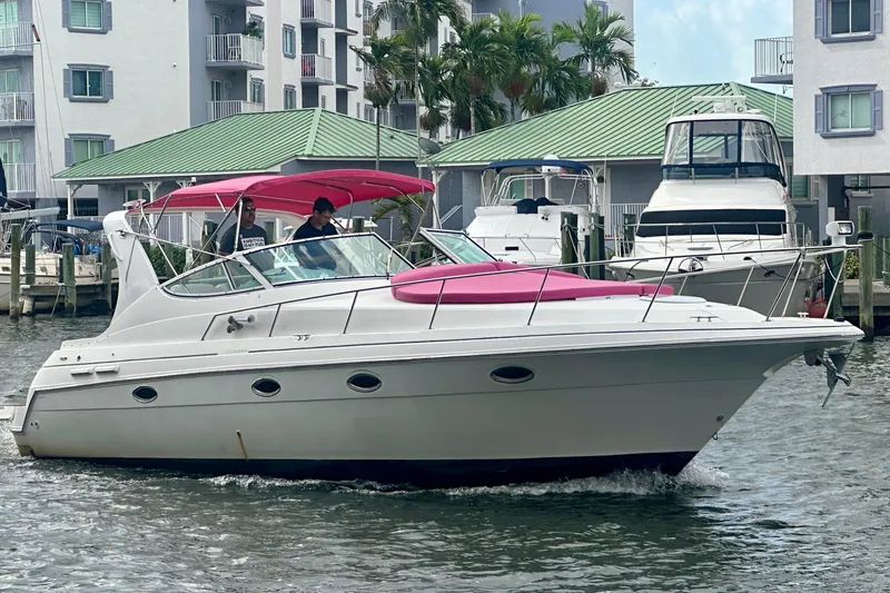 Slide: The Image of 2001 Sea Ray 340 Sundancer yacht cruising near waterfront buildings. - 3