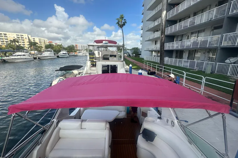 Slide: The Image of 2001 Sea Ray 340 Sundancer with pink canopy docked near waterfront buildings. - 36