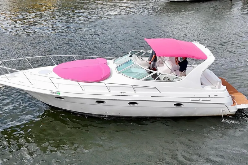 Slide: The Image of 2001 Sea Ray 340 Sundancer with pink canopy cruising on water. - 6