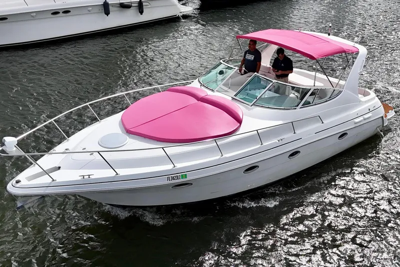 Slide: The Image of 2001 Sea Ray 340 Sundancer boat with pink accents cruising on water. - 9