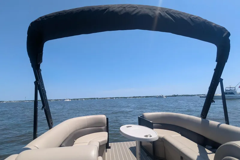 Slide: The Image of 2022 Bentley Pontoons 240 Navigator on water, featuring spacious seating and canopy. - 5