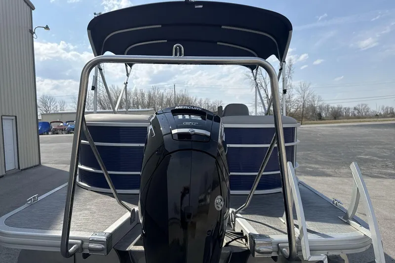 Slide: The Image of 2023 Bennington 25ssrc pontoon boat with Mercury outboard motor, docked outdoors. - 13