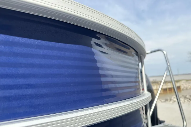 Slide: The Image of Close-up of a 2023 Bennington 25ssrc boat's blue exterior with metallic accents. - 21