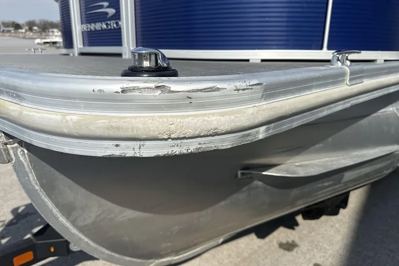 Slide: The Image of 2023 Bennington 25ssrc pontoon boat with visible hull scratches and dock cleat. - 22