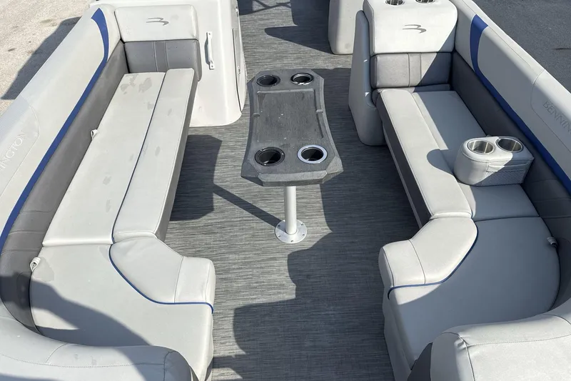 Slide: The Image of 2023 Bennington 25ssrc boat interior with gray seating and central table. - 7