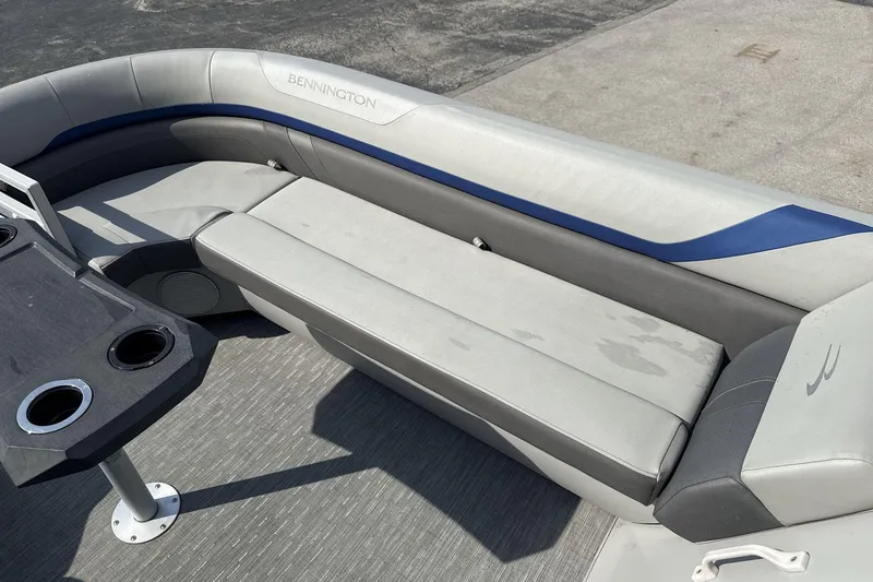 Slide: The Image of 2023 Bennington 25ssrc boat interior with gray seating and cup holders. - 9