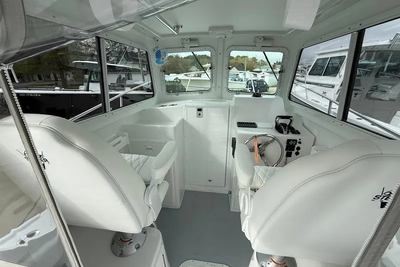 Slide: The Image of 2026 Steiger Craft 255 Miami boat interior with white seating and control panel. - 10