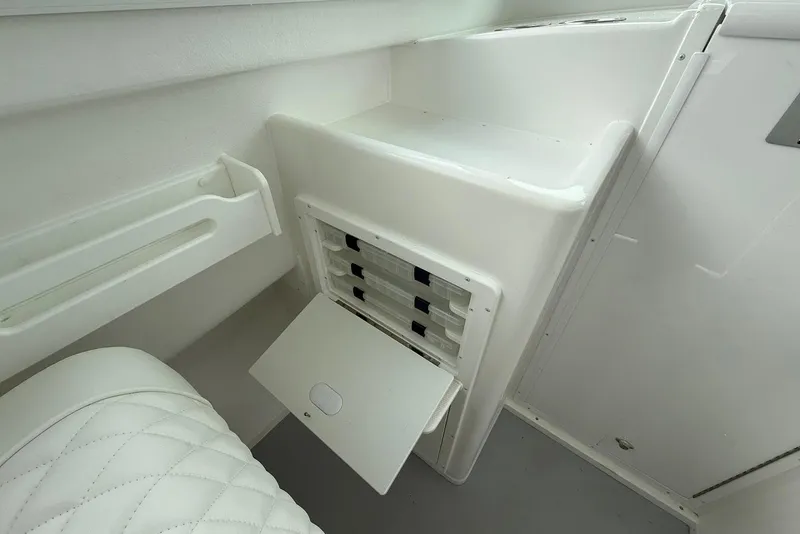 Slide: The Image of 2026 Steiger Craft 255 Miami interior storage compartment with white seating and sleek design. - 13