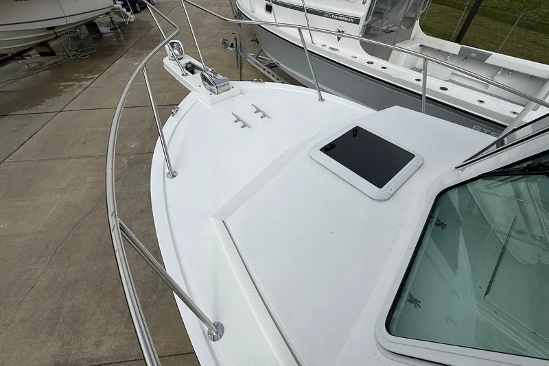 Slide: The Image of 2026 Steiger Craft 255 Miami boat deck with railing and hatch, docked on concrete. - 16