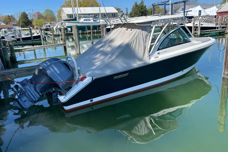 The Image of 2016 Pursuit DC 265 Dual Console boat docked with Yamaha outboard motor. - 0