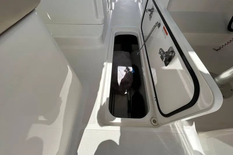 Slide: The Image of Storage compartment on a 2016 Pursuit DC 265 Dual Console boat, open and empty. - 14