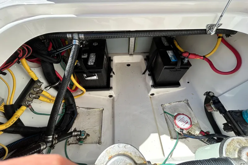 Slide: The Image of Battery compartment of a 2016 Pursuit DC 265 Dual Console boat with wiring and connections. - 16