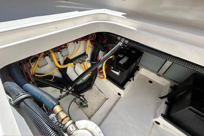 Slide: The Image of 2016 Pursuit DC 265 Dual Console boat wiring and battery compartment. - 17