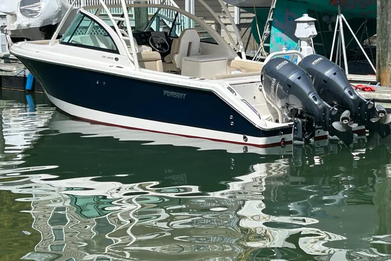 Slide: The Image of 2016 Pursuit DC 265 Dual Console boat docked with twin outboard engines. - 24