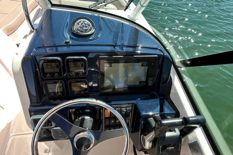 Slide: The Image of Dashboard of a 2016 Pursuit DC 265 Dual Console boat with navigation instruments. - 5
