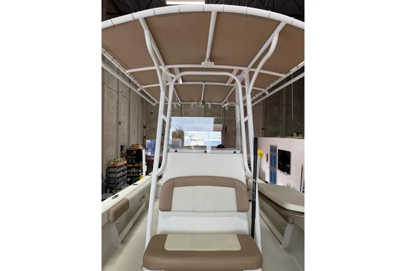 Slide: The Image of 2018 Parker 2100 SE boat interior with seating and canopy in a workshop. - 21