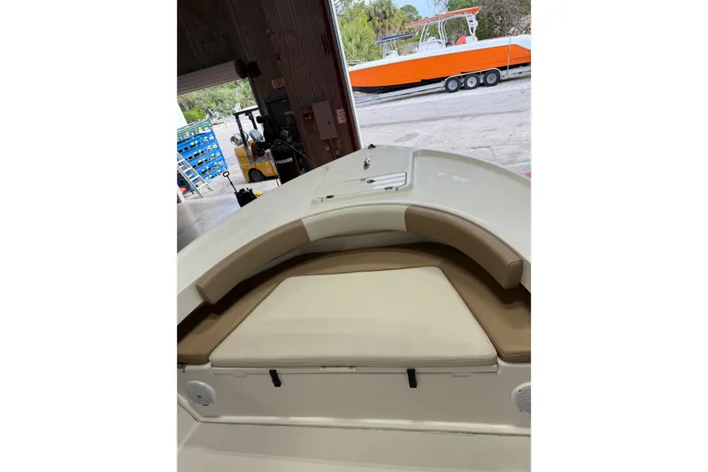 Slide: The Image of 2018 Parker 2100 SE boat interior with cushioned seating in a garage setting. - 23