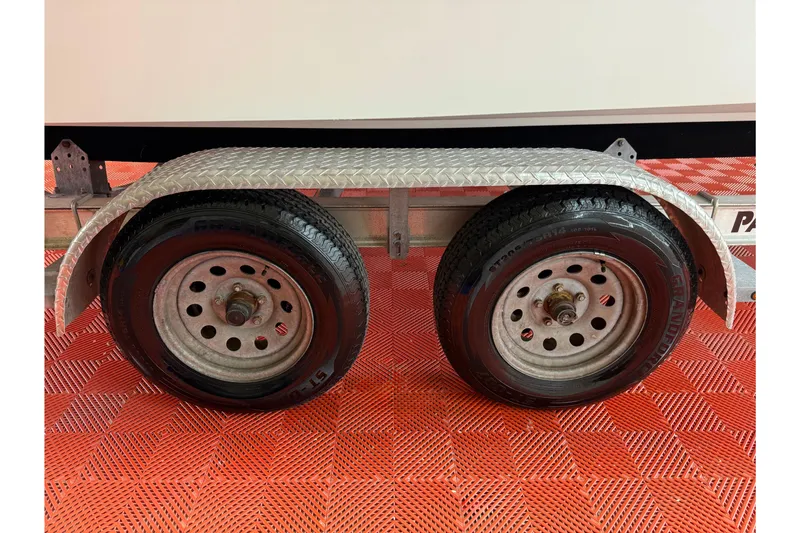 Slide: The Image of Trailer wheels of a 2018 Parker 2100 SE on red checkered flooring. - 34