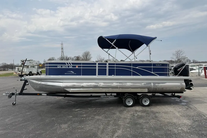 Slide: The Image of 2023 Bennington 25ssrc pontoon boat with blue canopy on a trailer. - 12
