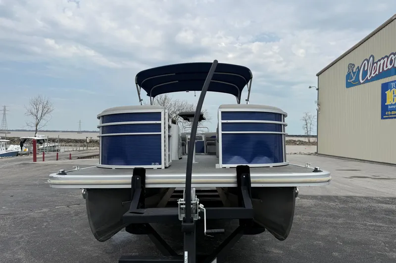Slide: The Image of 2023 Bennington 25ssrc pontoon boat on trailer at marina, under cloudy sky. - 15